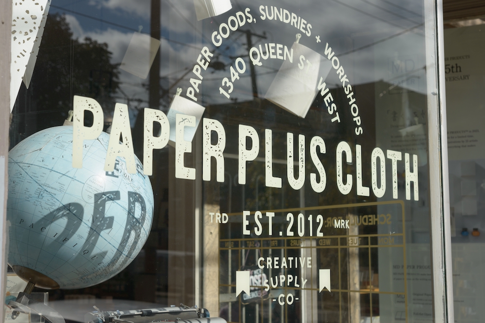 white ink printing spot white vinyl window graphic applied to a storefront window