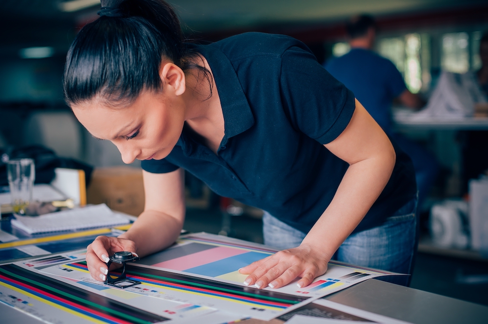 A woman using a spectrophotometer and Flexi to improve color accuracy in wide-format printing
