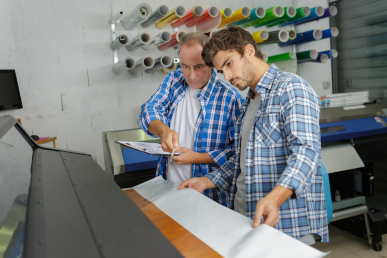 Designers preparing artwork as part of an integrated design-to-RIP workflow in a professional print shop