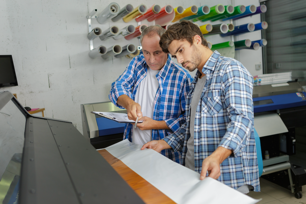 Designers preparing artwork as part of an integrated design-to-RIP workflow in a professional print shop